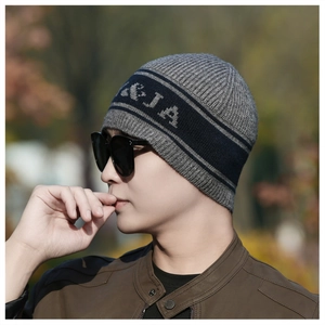 Détail du bonnet en maille rayé gris et noir avec texture jacquard à lettres contrastées