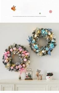 Detail of a frosted Christmas wreath with LED lights, blue ornaments, and festive bows