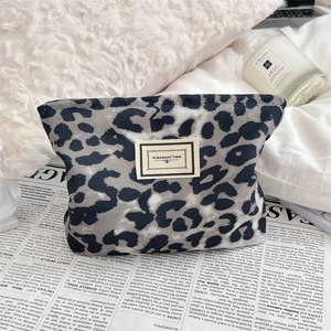 Dettaglio della borsa per cosmetici in velluto a coste leopardato su base morbida