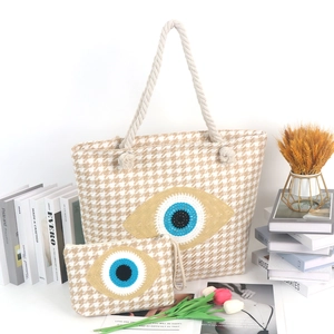 Detail of woven tote bag set with evil eye embroidery and rustic hemp rope handles