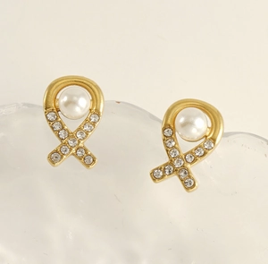 Détail de boucles d'oreilles ruban en or 18 carats avec perle et cristaux brillants