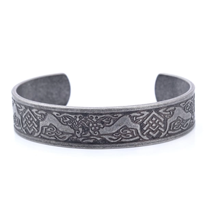 Close-up of Celtic dragon relief patterns on a vintage steel open cuff bracelet