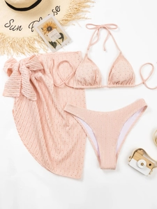 Detailansicht des rosa dreiteiligen Bikinis mit hohler Strickstruktur und Sarong-Rock