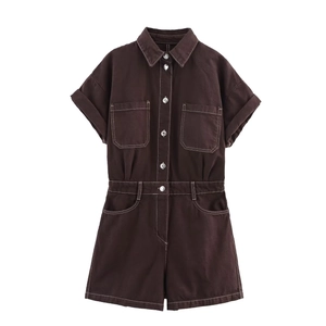 Detail of brown utility romper showing white contrast stitching and breast pockets