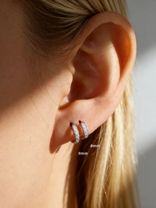 Close-up of 8mm and 9mm S925 silver huggie earrings with sparkling zircon inlay