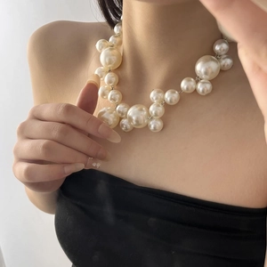 Close-up of French vintage faux pearl choker with mixed size beads on model neck