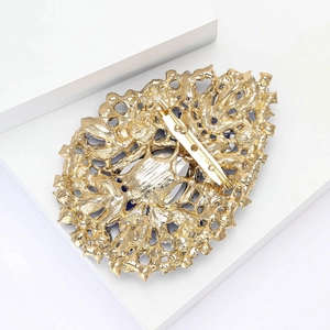 Macro shot of the golden filigree metal brooch back showing the secure pin fastener