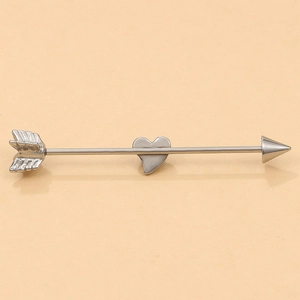 Detailed view of silver industrial barbell earring with arrow ends and heart pendant