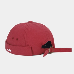 Detail of adjustable metal buckle and fish embroidery on burgundy docker cap