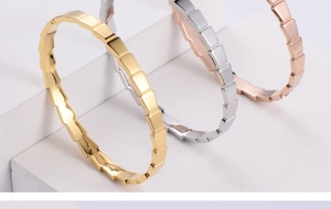 Detailed view of geometric scale bracelets in gold, silver, and rose gold finishes