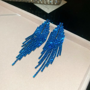 Détail de boucles d'oreilles de luxe à franges bleues multicouches avec strass brillants