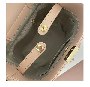 Top view of pink bucket bag interior showing gold zipper pocket and magnetic snap button