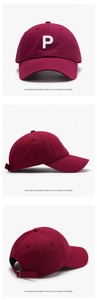 Detail view of burgundy baseball cap featuring white 3D letter P embroidery and metal buckle