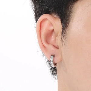 Gros plan d'une boucle d'oreille en acier argenté avec cristaux sur un mannequin femme