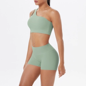 Detail eines salbeigrünen Yoga-Sets mit One-Shoulder-Top und hochtaillierter Shorts
