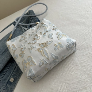 White jacquard canvas tote bag with blue butterfly embroidery and woven shoulder strap
