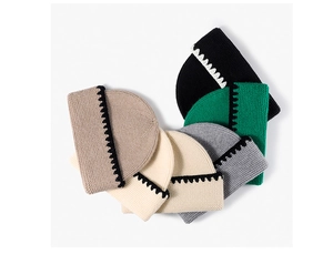 Detail of ribbed knit beanies with contrasting scalloped edges in multiple colors