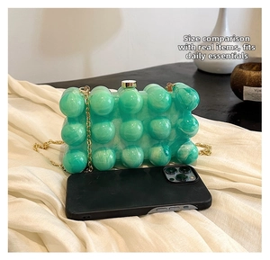 Vue détaillée de la pochette à bulles en acrylique vert émeraude avec chaîne dorée