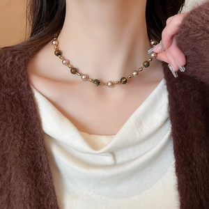 Detail of vintage tiger eye and gold beaded necklace worn elegantly on a model