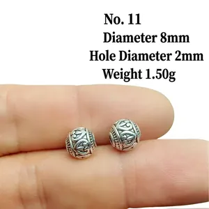 Macro detail of 8mm vintage alloy lantern beads with embossed floral pattern for DIY jewelry