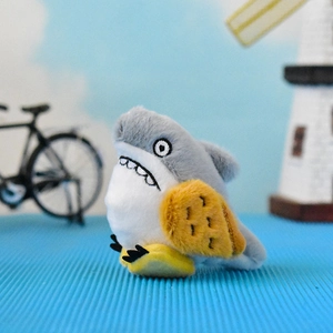 Close-up of a funny shark-bird hybrid plush toy keychain with unique teeth design