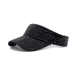 Detailed close-up of a black sun visor hat featuring intricate rhinestone beadwork