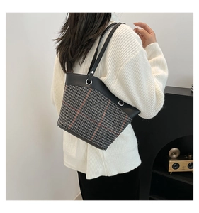 Close-up of vintage plaid bucket bag with houndstooth texture and leather trim details