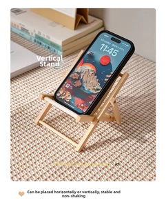 Vertical view of a mini wooden beach chair phone stand with white canvas on desk