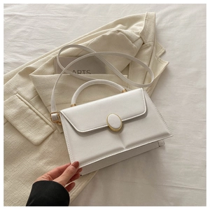 Détail du sac à bandoulière en cuir PU blanc avec boucle dorée sur blazer en lin beige