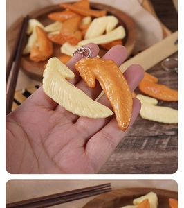 Detailed macro view of realistic chicken wing keychains showing texture and hand-held close-up