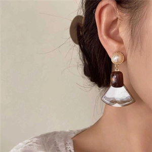 Retro geometric resin fan-shaped pearl earrings on a model with gold metal details