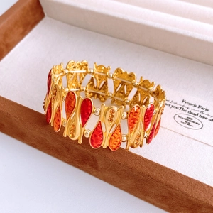 Detail of vintage teardrop bangle with red enamel inlay and zircon on jewelry box