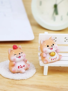 Detailed close-up of two cute resin Shiba Inu figurines on a cozy miniature chair
