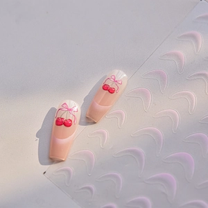 Detail showing cherry and bow nail art stickers with French tip guide templates