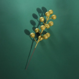 Detail of a golden glitter berry branch for Christmas decoration on a dark background