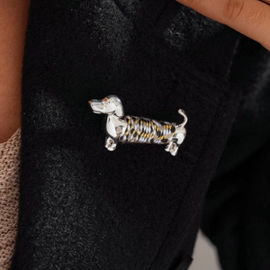 Detail of woven fiber rope texture on a silver dachshund dog brooch pinned to a black coat