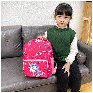 Pink unicorn kids backpack with rainbow patterns shown in a lifestyle setting