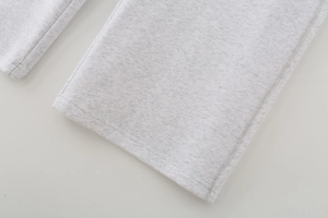 Detailed view of light gray knitted joggers showing high-quality hem stitching and texture