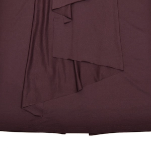 Gros plan sur la texture du tissu en maille bordeaux avec détails de couture d'ourlet