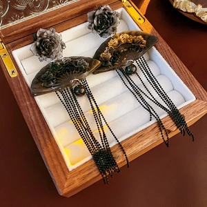 Detail shot of vintage Chinese style earrings with black roses and tassel in a wooden box