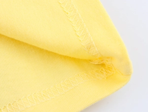 Macro delle cuciture precise e del dettaglio dell'orlo sulla t-shirt in cotone giallo