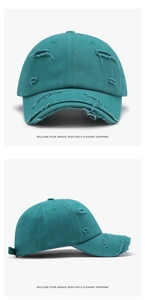 Close-up of teal distressed cotton baseball cap showing frayed details and washed texture