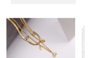 Close-up of golden multi-layer necklace with blue evil eye and star charms