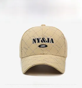 Detail of beige baseball cap featuring diamond lattice stitching and black NY&JA embroidery