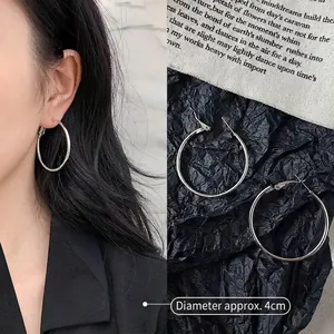 Detailed view of large silver hoop earrings showing 4cm diameter and polished metal finish