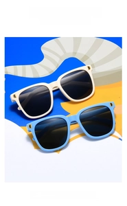 Détail de lunettes de soleil carrées pour enfants en beige et bleu ciel avec logo D