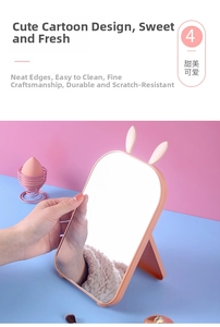 Close-up of pink rabbit ear folding makeup mirror with adjustable desktop stand base