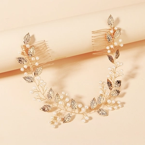 Golden bridal hair comb with elegant metal leaves and white pearls for wedding hairstyles