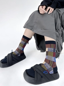 Close-up of retro color-block checkered socks worn with black platform slippers