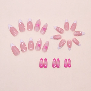 Détail de faux ongles amande avec perles fleurs de glace et cristaux de strass